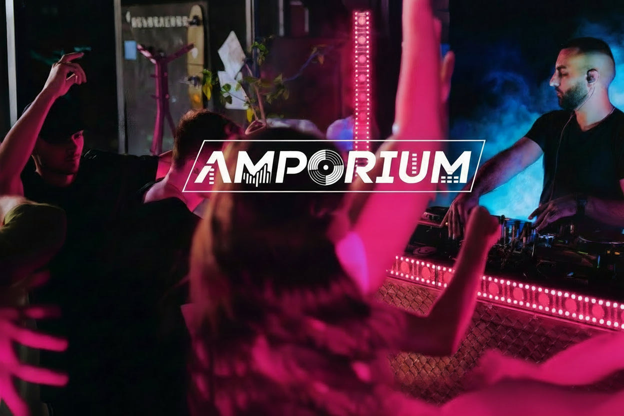  DJ performing on a stage with 'Amporium' branding and text 'Ready When The Beat Drops'.